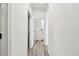 Bright hallway featuring wood-look floors and white trim throughout at 310 Blackrock Ln, Apollo Beach, FL 33572