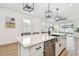 Kitchen island with stainless steel sink, white countertop, and seating for four at 310 Blackrock Ln, Apollo Beach, FL 33572