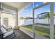 Screened patio with brick floor and outdoor furniture overlooking the fenced backyard at 310 Blackrock Ln, Apollo Beach, FL 33572