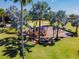 Aerial view of a playground with a sunshade, surrounded by palm trees and beautiful landscaping at 310 Blackrock Ln, Apollo Beach, FL 33572