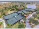 Aerial view of multiple community tennis courts surrounded by lush greenery and mature trees at 310 Blackrock Ln, Apollo Beach, FL 33572