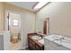 Neutral bathroom with tiled walls, vanity, and a doorway leading to the toilet and shower at 38928 Tall Dr, Zephyrhills, FL 33540