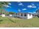 Wide angle of fenced in backyard showing the house, yard, and some trees at 4529 Olive Dr, Zephyrhills, FL 33542