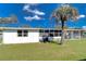 Exterior view of the property highlighting the fenced backyard, mature trees, and covered porch at 4529 Olive Dr, Zephyrhills, FL 33542