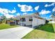 Charming home exterior featuring a covered parking area and well-maintained lawn at 4529 Olive Dr, Zephyrhills, FL 33542