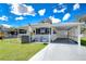 Exterior view showcases the home's carport, manicured lawn, and inviting curb appeal at 4529 Olive Dr, Zephyrhills, FL 33542