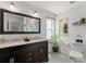 Well-lit bathroom featuring a dark wood vanity, double sinks, and modern fixtures at 4706 Shale Pl, Tampa, FL 33615