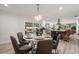 Open-concept dining room with a modern chandelier, dining table with seating, and backyard view at 4706 Shale Pl, Tampa, FL 33615