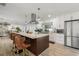 Modern kitchen featuring a large island with bar stools, stainless steel appliances, and sleek white cabinets at 4706 Shale Pl, Tampa, FL 33615