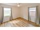 Bright bedroom with wood-look floors, ceiling fan, and two windows with stylish curtains at 4710 23Rd S Ave, St Petersburg, FL 33711