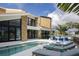 Modern home exterior with a pool, lounge chairs, and waterfront views under a partly cloudy sky at 4900 59Th S Ave, St Petersburg, FL 33715