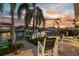 Waterfront backyard patio featuring outdoor seating, palm trees, boats, and a stunning sunset view at 4930 60Th S Ave, St Petersburg, FL 33715