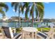 Inviting waterfront patio with chairs and table, offering scenic views of the canal and boat docks at 4930 60Th S Ave, St Petersburg, FL 33715