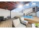 Backyard pool deck offers seating and a staircase to upper level, surrounded by screened walls at 5011 S Elberon St, Tampa, FL 33611