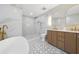 Luxurious bathroom features marble tile, soaking tub, double vanity, and walk-in shower at 5011 S Elberon St, Tampa, FL 33611