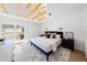 Bright bedroom features exposed beams, a sliding door to a balcony, and a cozy area rug at 5011 S Elberon St, Tampa, FL 33611