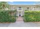 Charming townhouse featuring gated brick entry, mature landscaping, and upper level balcony at 5011 S Elberon St, Tampa, FL 33611