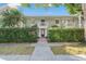 Facade view of the building behind a gate and hedge, featuring a second-story balcony at 5011 S Elberon St, Tampa, FL 33611