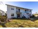 Two-story condo building with white stairs and balconies with a green lawn at 522 Pine Ave # 6A, Anna Maria, FL 34216