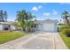 Charming single-story home featuring a well-manicured lawn, a driveway and attractive landscaping with several palm trees at 5926 Bayou Grande Ne Blvd, St Petersburg, FL 33703