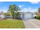 Charming single Gathering home with a manicured lawn, mature palm trees, and attached one car garage at 5926 Bayou Grande Ne Blvd, St Petersburg, FL 33703