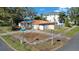 Charming single-story home with a red tile roof, a white fence, and mature trees on a corner lot at 601 Cordova Ne Blvd, St Petersburg, FL 33704