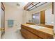 Bathroom features a sink with wooden cabinets and a full mirror and tiled flooring at 6104 Dory Way, Tampa, FL 33615