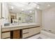 Bright bathroom with a dual vanity, large mirror, and a bathtub with shower at 6104 Dory Way, Tampa, FL 33615