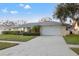 Inviting single-story home with a two-car garage, stone detailing and mature trees at 6104 Dory Way, Tampa, FL 33615