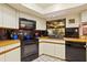 Charming kitchen showcasing white cabinets and sleek black appliances at 6104 Dory Way, Tampa, FL 33615