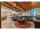 Expansive living room featuring a wood-beam ceiling, sleek tile flooring, and comfortable lounge seating at 6104 Dory Way, Tampa, FL 33615