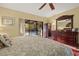 Serene bedroom featuring a fan, a sliding glass door view of the pool, and warm lighting at 6104 Dory Way, Tampa, FL 33615