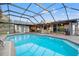 Screened in Pool with brick trim, stone floor, house visible through screen, and blue skies at 6104 Dory Way, Tampa, FL 33615