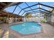 Screened in Pool with brick trim, stone floor, palm trees visible through screen, and lounge chairs at 6104 Dory Way, Tampa, FL 33615