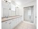 A bathroom has double sinks, tiled floor, white cabinets, and a glass enclosed shower at 615 Olive Tree Ct, Clearwater, FL 33756