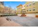 Exterior view of a three-story tan townhome with attached garage and a tile roof at 615 Olive Tree Ct, Clearwater, FL 33756