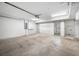 Spacious garage with white walls, concrete floor, shelving, and an automatic door at 615 Olive Tree Ct, Clearwater, FL 33756