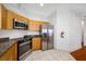 Bright kitchen featuring wood cabinets, stainless steel appliances, and granite countertops at 615 Olive Tree Ct, Clearwater, FL 33756