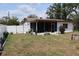 View of the backyard featuring a screened-in porch and a white vinyl fence at 6188 Pinehurst Dr, Spring Hill, FL 34606