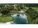 An aerial view of a lakefront property featuring a home with a pool and golf course at 7078 Lexington Cir, Brooksville, FL 34602