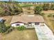 Aerial view of a home with a long driveway and golf course views in the distance at 7078 Lexington Cir, Brooksville, FL 34602