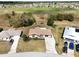 Aerial view of a home with a long driveway and golf course views in the distance at 7078 Lexington Cir, Brooksville, FL 34602