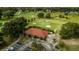 Overhead view of a golf course with a clubhouse, meticulously landscaped grounds, and parking at 7078 Lexington Cir, Brooksville, FL 34602