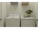 Well-lit laundry room with modern appliances, wire shelving, and decorative plant at 7516 E 116Th St, Palmetto, FL 34221