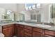 Bathroom featuring dual sinks, granite counters, large mirror, and glass enclosed shower at 1001 Bayvista Dr, Tarpon Springs, FL 34689