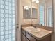 Bright bathroom features stylish glass door and sink with cabinet storage at 1001 Bayvista Dr, Tarpon Springs, FL 34689