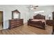 Spacious main bedroom featuring elegant wood furniture, flooring, and a ceiling fan at 1001 Bayvista Dr, Tarpon Springs, FL 34689