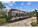 Screened-in pool with outdoor seating, plants, and partial shade at 1001 Bayvista Dr, Tarpon Springs, FL 34689