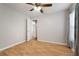 Cozy bedroom with a ceiling fan, wood-look flooring, and a view into the hallway through a white door at 11248 Andy Dr, Riverview, FL 33569