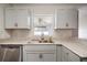 Kitchen featuring stainless steel dishwasher, gray cabinets, granite countertops, and a window above the sink at 11248 Andy Dr, Riverview, FL 33569